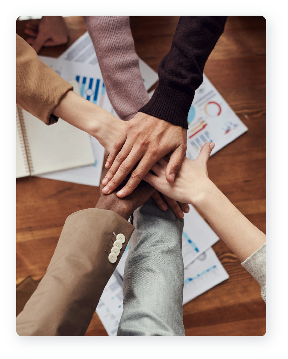Hands stacked on top of each other in a show of teamwork.
