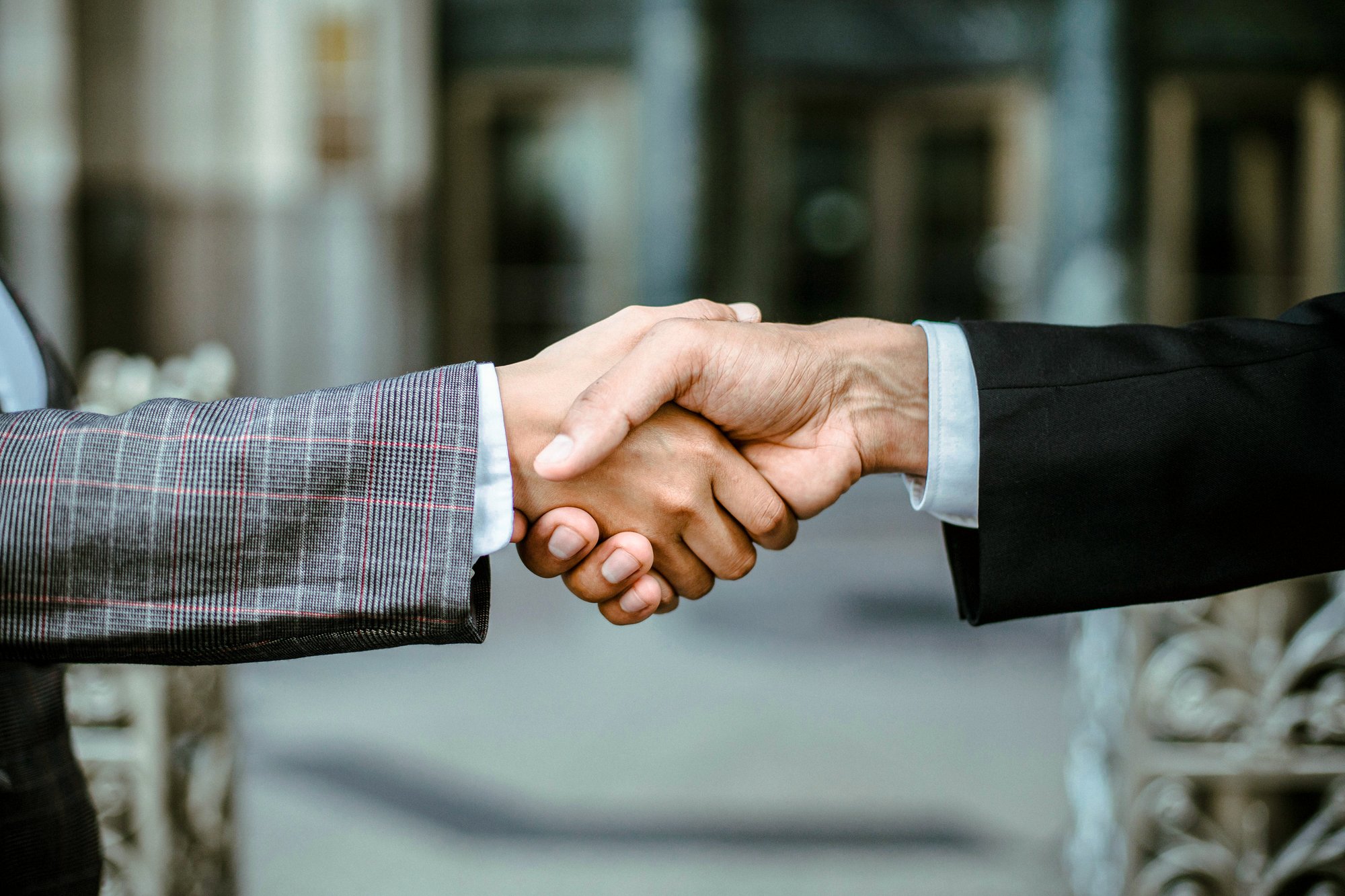 Two masculine hands clasped in a handshake.
