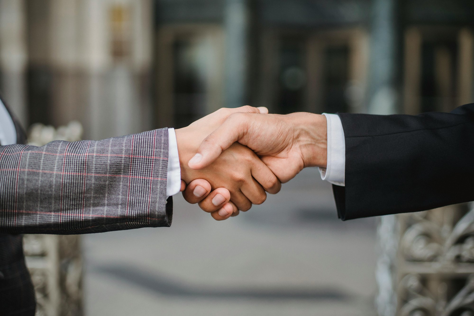 Two masculine hands clasped in a handshake.